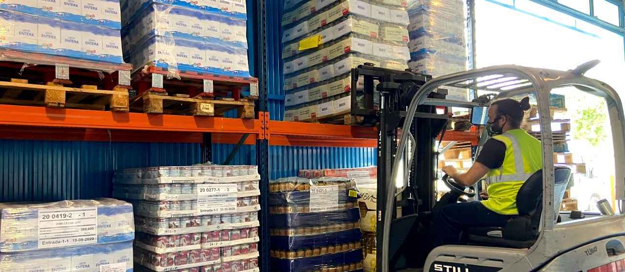 Carretillero transportando los palés de alimentos en el Banco de Alimentos de Sevilla