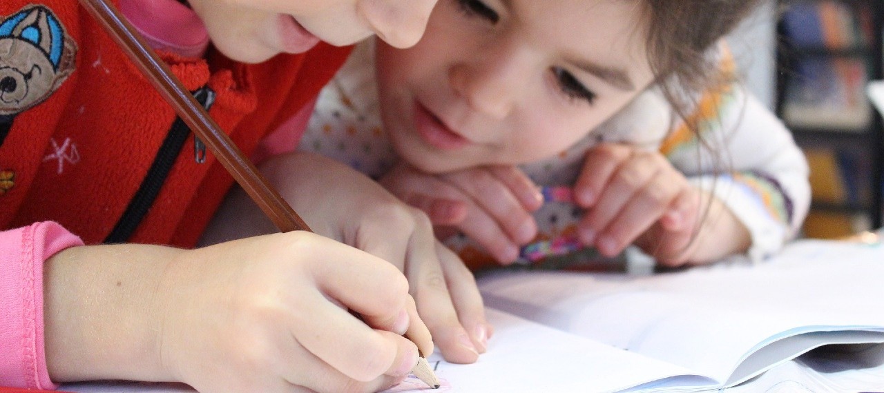 Foto de dos niñas escribiendo en una libreta